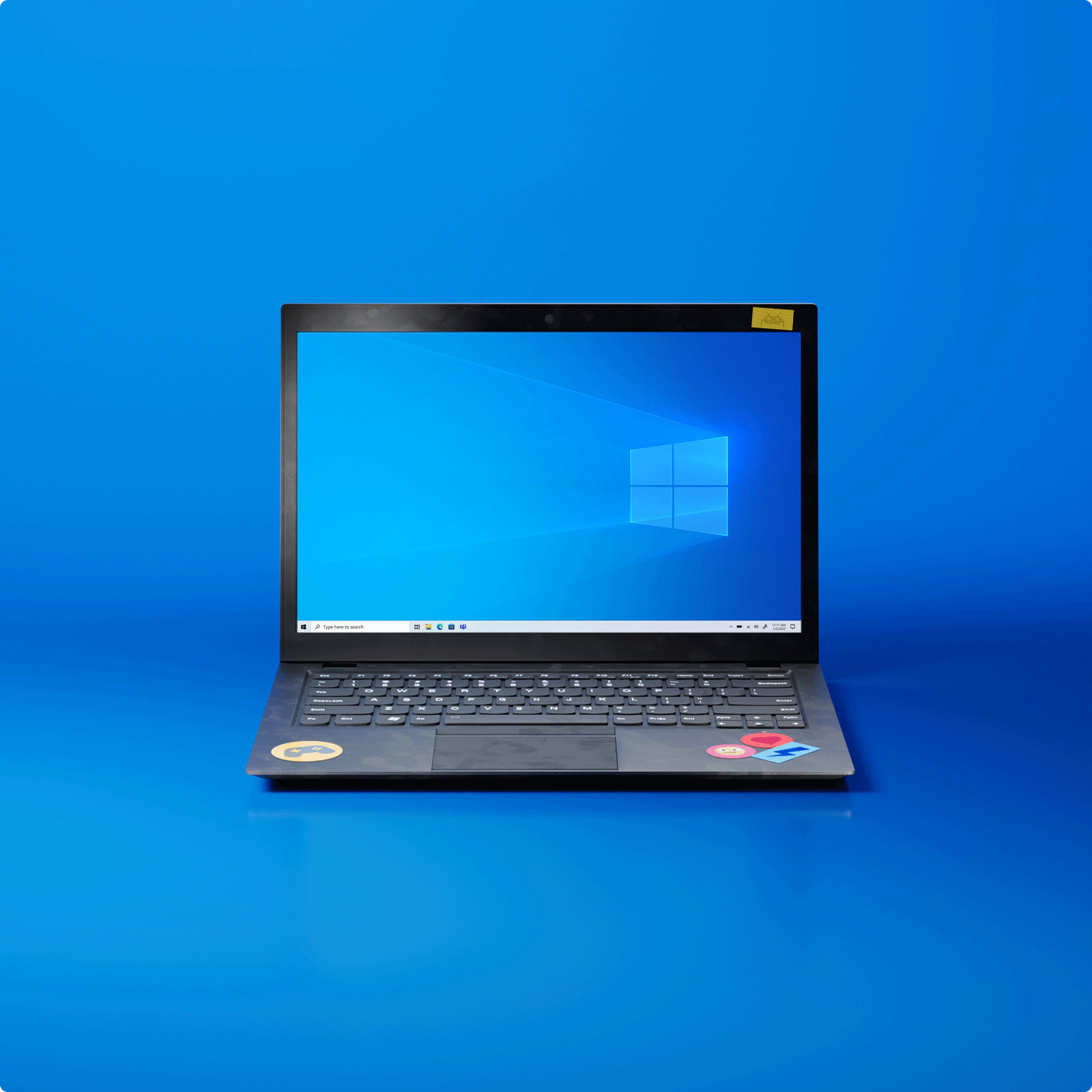 An open Windows 10 Microsoft laptop with a Windows 10 logo on the screen on a blue background