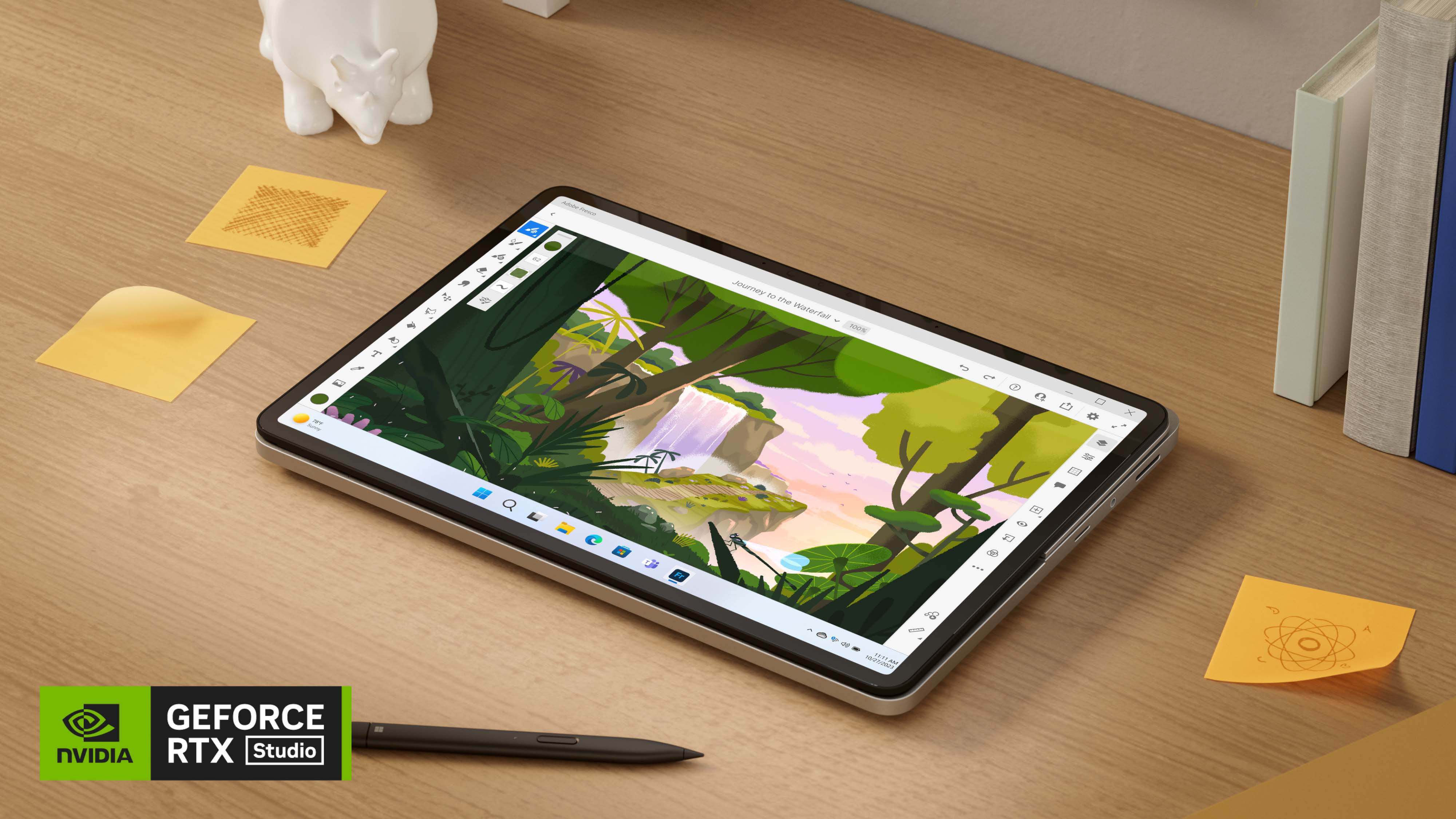 Surface Laptop Studio 2 في الوضع اللوحي على طول قلم Surface Slim Pen وورق الملاحظات اللاصقة على مكتب خشبي.